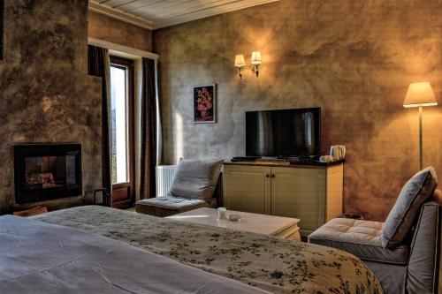 a bedroom with a bed and a tv and a couch at Guesthouse likoria in Arachova