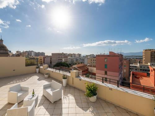 a balcony with chairs and a view of a city at B&B Palazzo Merello in Cagliari