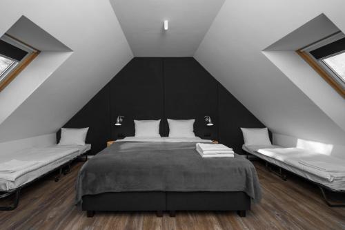 a black and white bedroom with a bed and two benches at dobra truskawka in Wągrowiec