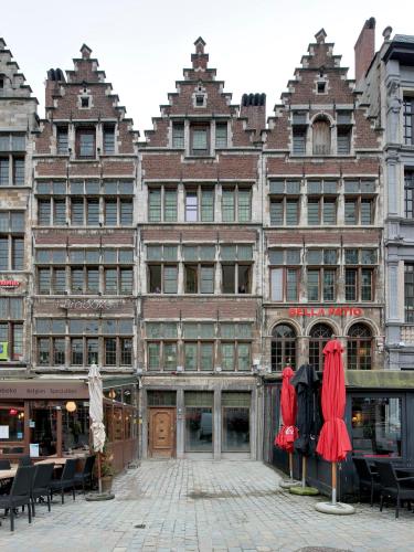 a large building with red umbrellas in front of it at Antwerp old town appartment in Antwerp