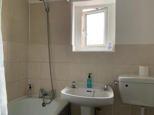een badkamer met een wastafel, een toilet en een douche bij Winstanley House in Wellingborough