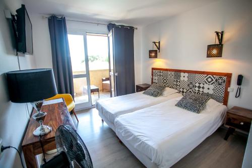 een slaapkamer met een bed en een kamer met een raam bij La Picholine in Nyons
