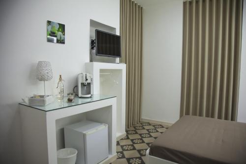 a room with a bed and a tv on a fireplace at VILLA ADELAIDE SUITE & ROOM in Torre a Mare