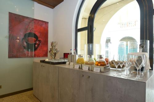 a counter with a bunch of glass items on it at Hotel Canon d'Oro in Conegliano