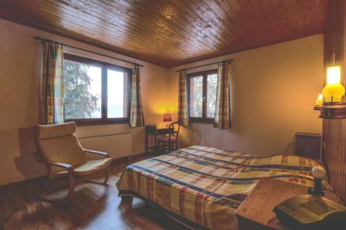 1 dormitorio con 1 cama, 1 silla y 2 ventanas en Modern and well equipped apartment, 500m from the 4 Vallées ski area, en Agettes