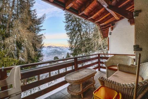 un balcone con tavolo e sedie e vista di Modern and well equipped apartment, 500m from the 4 Vallées ski area ad Agettes