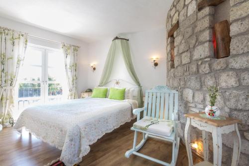 a bedroom with a bed and a stone wall at Chigdem Hotel-Special Category in Alaçatı