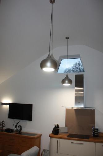 a room with two lights hanging from the ceiling at Ferndown Holiday Let in Ferndown