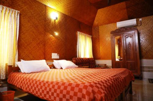 une chambre d'hôtel avec un lit et une couverture en damier dans l'établissement Cherai Beach Residency, à Cherai Beach