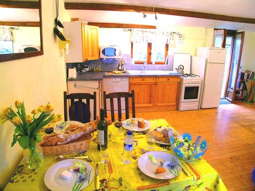 une cuisine avec une table et des assiettes de nourriture dans l'établissement La Roche Gite at Les Glycines Gites with Pool,Games Field in a peaceful,rural setting, à Scillé
