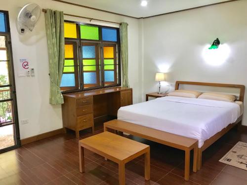 a bedroom with a bed and a stained glass window at Kawila126 in Chiang Mai
