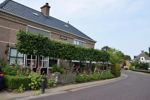 a building with ivy on the side of a street at d'AldeSkoalle in Molkwerum