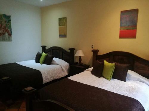 a hotel room with two beds with green pillows at Trapp Family Country Inn in San Antonio