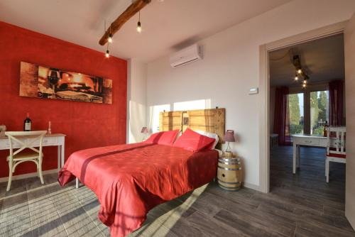 a bedroom with red walls and a bed with a red blanket at Agriturismo La Guarda in Picedo