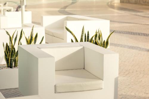 a white cube planter with some plants in it at Hotel Apartamento Dunamar in Monte Gordo