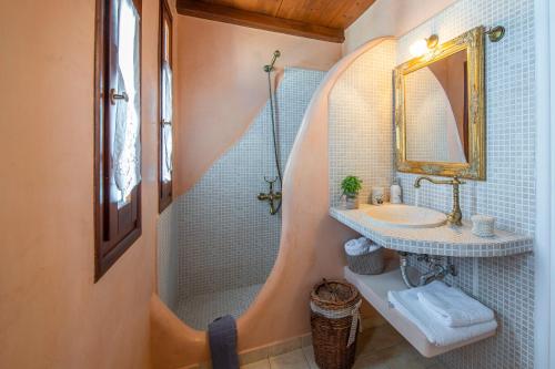 La salle de bains est pourvue d'une douche, d'un lavabo et d'un miroir. dans l'établissement Niriides Studios, à Pachaina