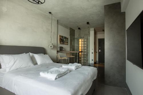 a bedroom with a white bed with towels on it at Urban Living 2 in Thessaloniki