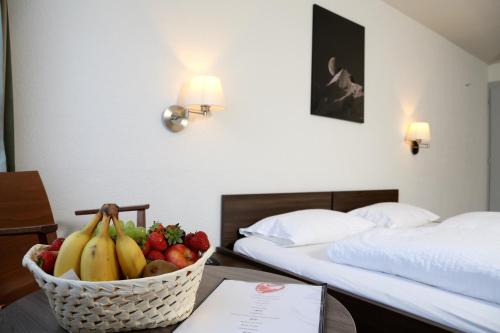 インターラーケンにあるHotel Crystal Interlakenのホテルの部屋のテーブルにフルーツバスケットを用意しています。