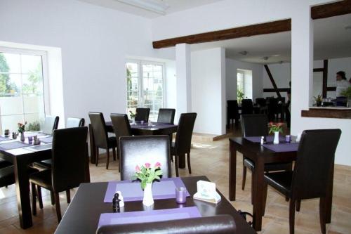 Landpension Strenz في Lüssow: غرفة طعام مع طاولات وكراسي ونوافذ
