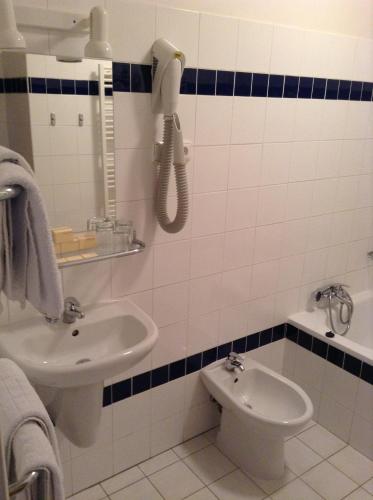 a bathroom with a sink and a phone on the wall at Penzion Luna in Brno