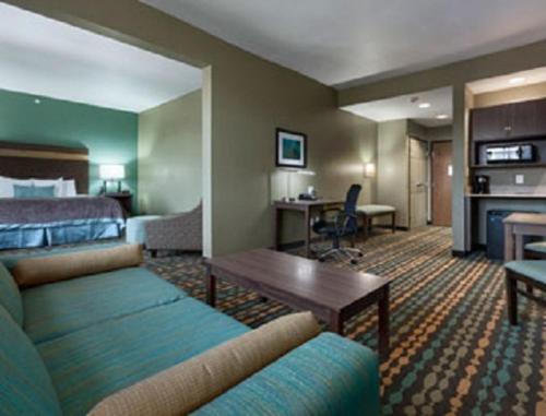 a hotel room with a bed and a living room at Wingate by Wyndham Bossier City in Bossier City