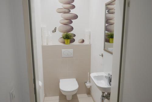 a white bathroom with a toilet and a sink at govienna - City Center Apartments in Vienna