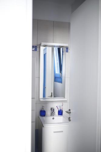 a white bathroom with a sink and a mirror at Serenity Kythnos in Kithnos