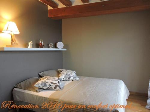 a bed with two pillows on it in a bedroom at Gîte de la Ferme de la Côte in Les Damps