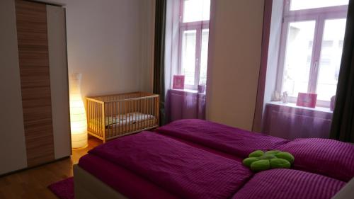 a bedroom with a purple bed with green fruit on it at govienna - City Center Apartments in Vienna