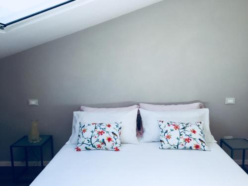 a bed with white sheets and pillows at Cocciopestorooms in Marina di Massa