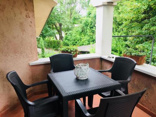 un tavolo nero e sedie su un portico con finestra di Cocciopestorooms a Marina di Massa