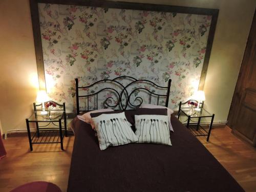 a bedroom with a bed with flowers on the wall at Gîte de la Ferme de la Côte in Les Damps