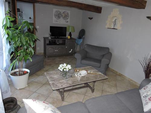 a living room with a couch and a coffee table at Gîte de la Ferme de la Côte in Les Damps