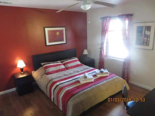 a bedroom with a bed with red walls and a window at Park-View Sleeps 12 3BR in Union City