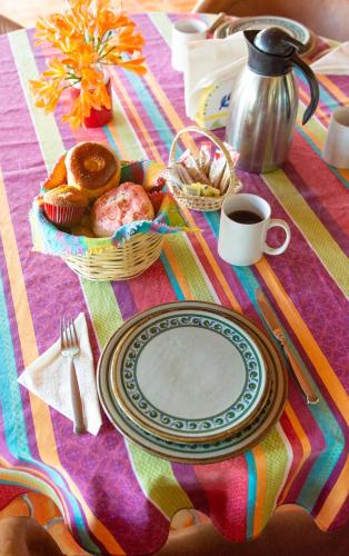 a table with a plate of food and a cup of coffee at Casa Palomas Bed and Breakfast in San Juan Cosalá