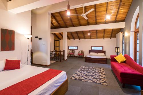 a bedroom with a bed and a couch in a room at Estancia Holiday Bungalow in Matale