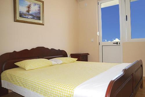 1 dormitorio con 1 cama con manta amarilla y blanca en Di Vincenzo Inn, en Ulcinj