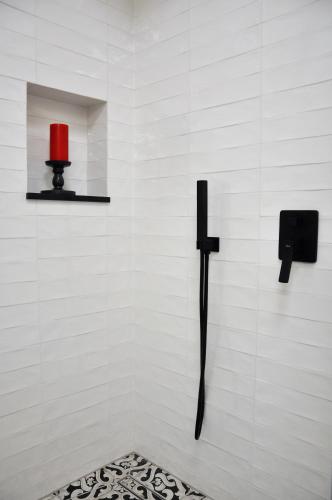 a wall with a black cross and a red lamp at Ludwinowska11 Apartments in Kraków