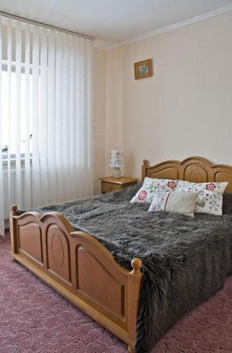 a bedroom with a large bed with a wooden frame at Pensiunea Aurora Izvorul Muntelui in Bicaz