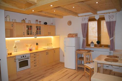 a kitchen with a white refrigerator and a table at Chata Romeo in Harmanec