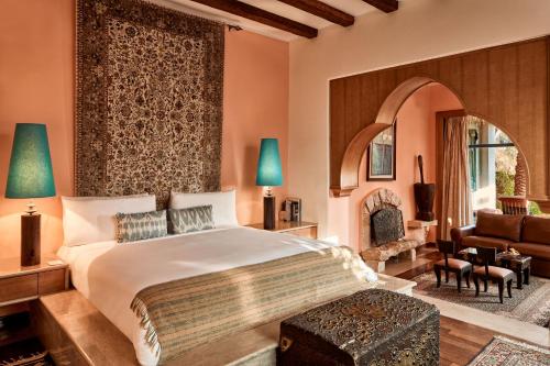1 dormitorio con 1 cama y sala de estar en Lazib Inn Resort & Spa en ‘Izbat an Nāmūs