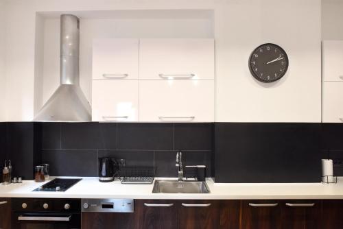 a kitchen with a sink and a clock on the wall at Apartments Belvedere in Belgrade