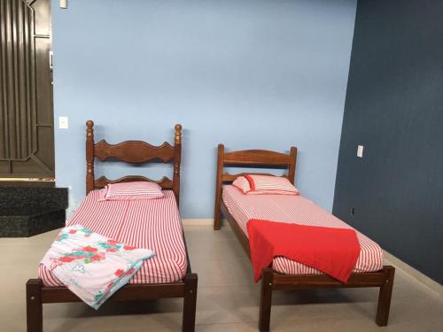 two beds sitting next to each other in a room at Bom Jardim in Piumhi