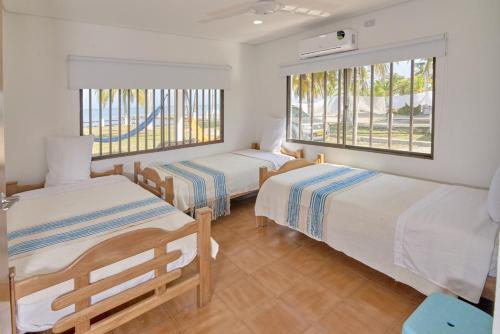 1 dormitorio con 2 camas y ventana en Cabaña El Refugio, en San Antero