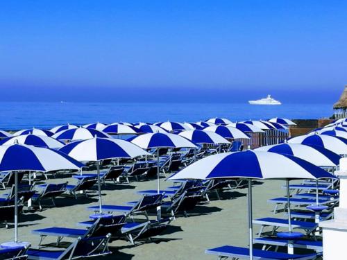 een bos blauwe en witte parasols op een strand bij Il Pirata Innamorato in Lido di Ostia