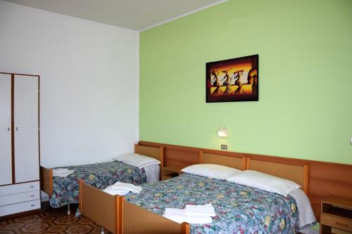a hotel room with two beds and a cabinet at Hotel Ristorante Da Marco in San Mauro a Mare