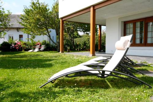 a stack of chairs sitting in the grass in front of a house at La Reserva de Los Campos in Cadavedo