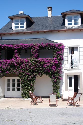a building with purple flowers on the side of it at La Reserva de Los Campos in Cadavedo
