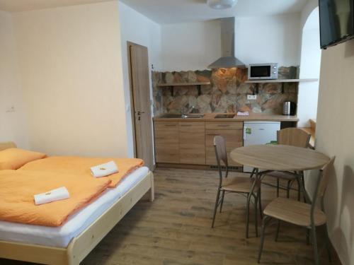 a bedroom with a bed and a table and a kitchen at Family apartments V Zátiší in Dolní Morava