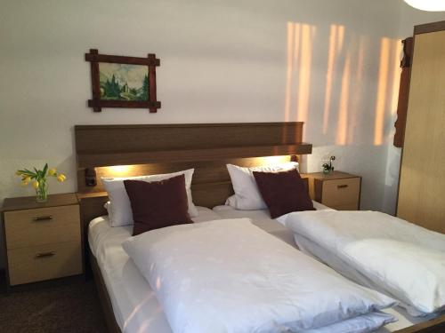 una camera con due letti con lenzuola bianche di Pension Berghof a Schönsee